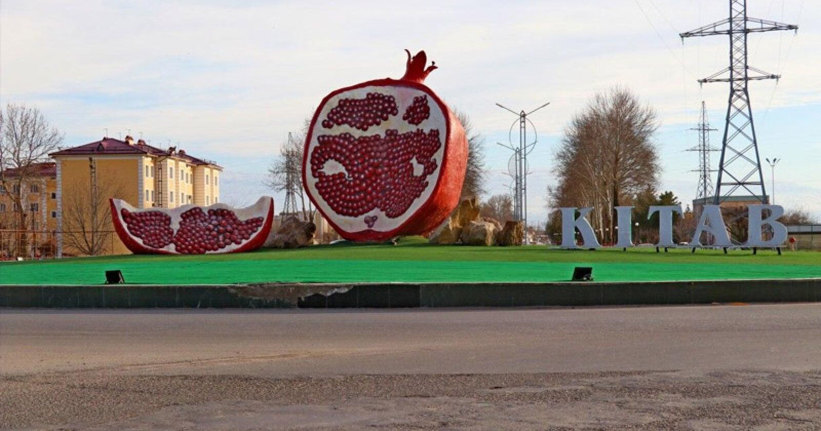 The giant pomegranate sculpture and KITAB letters at the entrance to Kitob